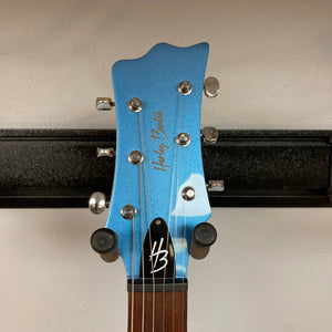 Harley Benton MR-Classic Vintage Metallic Blue Gloss Electric Guitar on a black stand, highlighting its high-output pickups and sturdy tuning machines.
