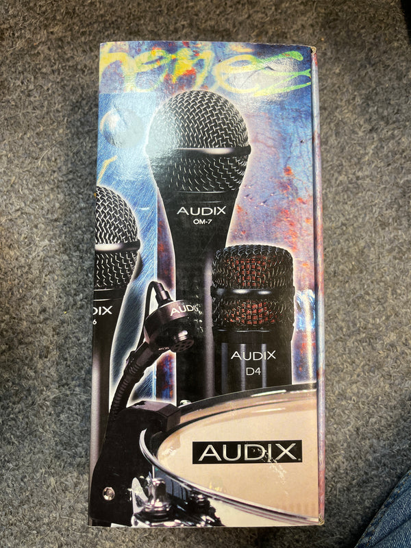A preowned Audix D2 Hypercardioid Dynamic Instrument Microphone in black rests on a black zippered pouch inside its cardboard box.