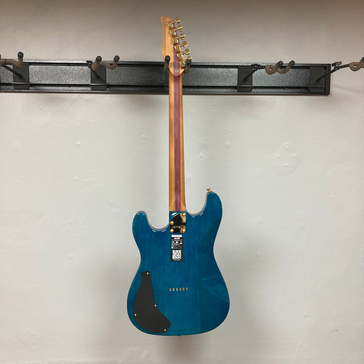Jamstik Deluxe MIDI Blue Guitar w/Case, featuring 24 frets, HH pickups, and MIDI capabilities, displayed on a wall.