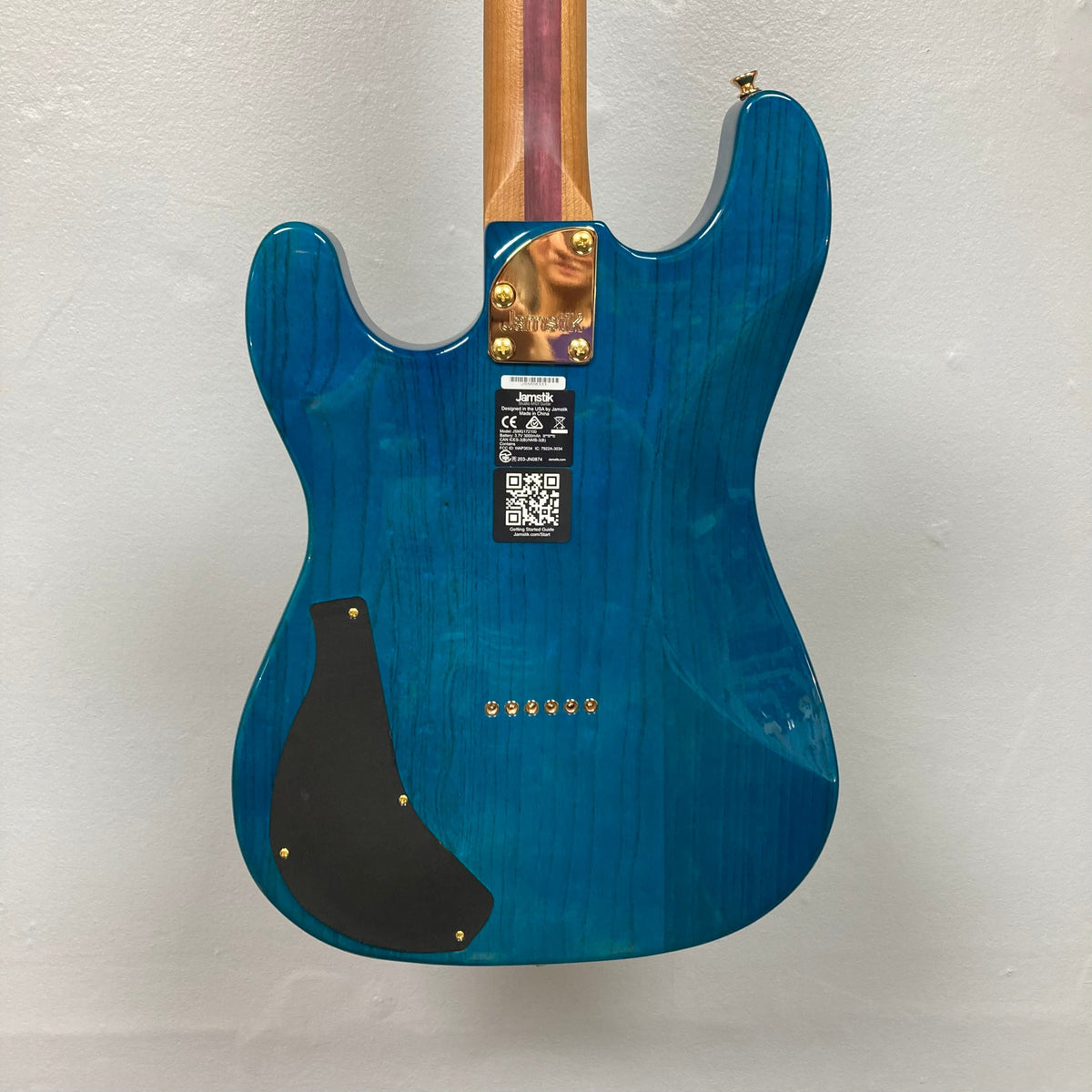 Jamstik Deluxe MIDI Blue Guitar w/Case, featuring 24 frets, HH pickup, locking tuners, hardtail bridge, and full MIDI capabilities, shown with a gold label.