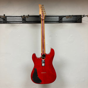 Jamstik Deluxe MIDI Red Black Guitar w/Case, high-performance electric guitar with 24 frets, HH pickups, and MIDI capabilities, displayed on a wall.