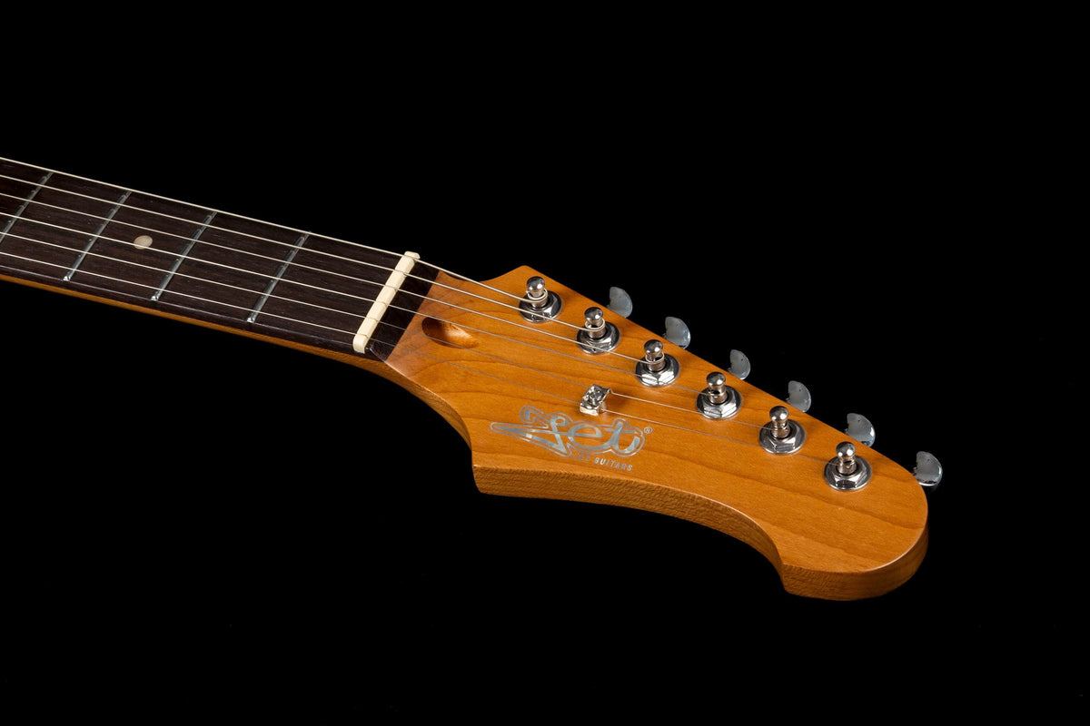 Close-up of the Jet JS-400 BKR H electric guitar headstock by Jet, showcasing its wooden finish with six tuning pegs, strings, and fretboard against a black background. Equipped with dual ceramic HH pickups, this guitar delivers versatile sound and modern playability for contemporary performance.