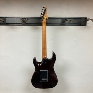 JET JS-450 Transparent Green guitar with a flamed maple top, HSS pickups, and Wilkinson Tremolo bridge, hanging on a wall.