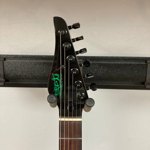 JET JS-450 Transparent Green guitar on a stand, showcasing its flamed maple top and modern design, ideal for versatile playability and performance.