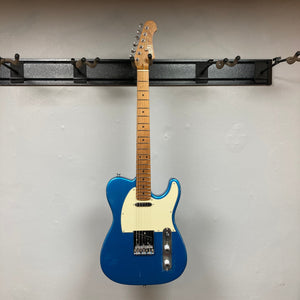 Jet JT-300 electric guitar with blue finish, featuring a Canadian roasted maple neck and chrome hardware, displayed on a wall.