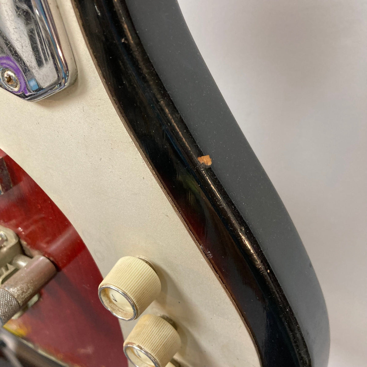 Close-up of the Kawai Vintage 1960s Kawai Teisco Japan Hound Dog Reburst electric guitar, showcasing its distinctive knobs and craftsmanship.