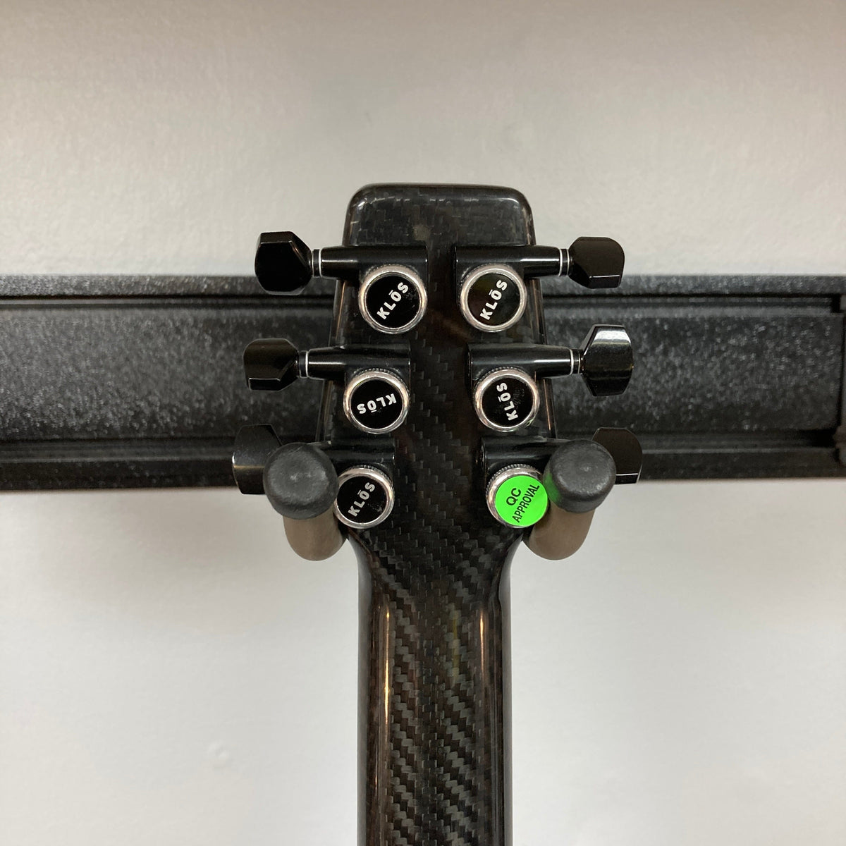 KLOS Apollo Pro Electric Guitar close-up, showing carbon fiber neck and aluminum strap pin buttons, highlighting its innovative design and craftsmanship.