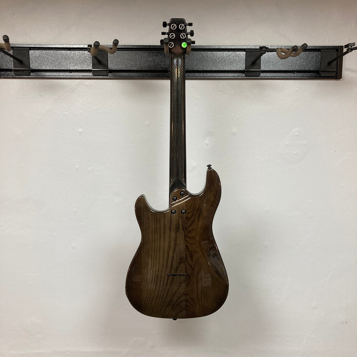 KLOS Apollo Pro Electric Guitar with carbon fiber neck, displayed on a wall, showcasing its modern design and innovative materials.