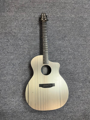 The Klos Grand Cutaway AE w/Fishman acoustic guitar, featuring a light wood finish and vertical grain lines, rests on a gray carpeted surface.