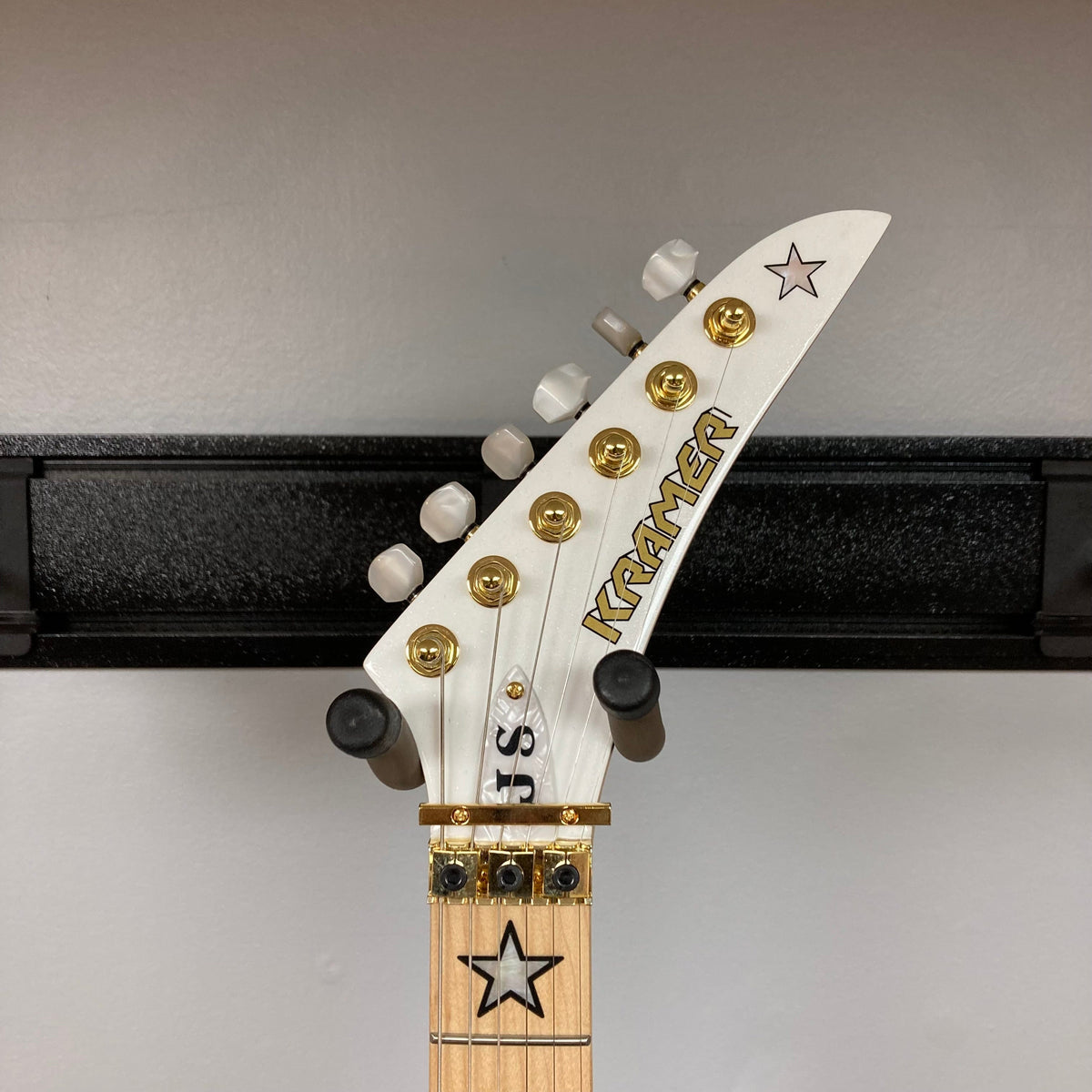 Kramer Jersey Star Pearl White w/Gigbag featuring gold hardware, mother-of-pearl star inlays, and three powerful humbucker pickups.