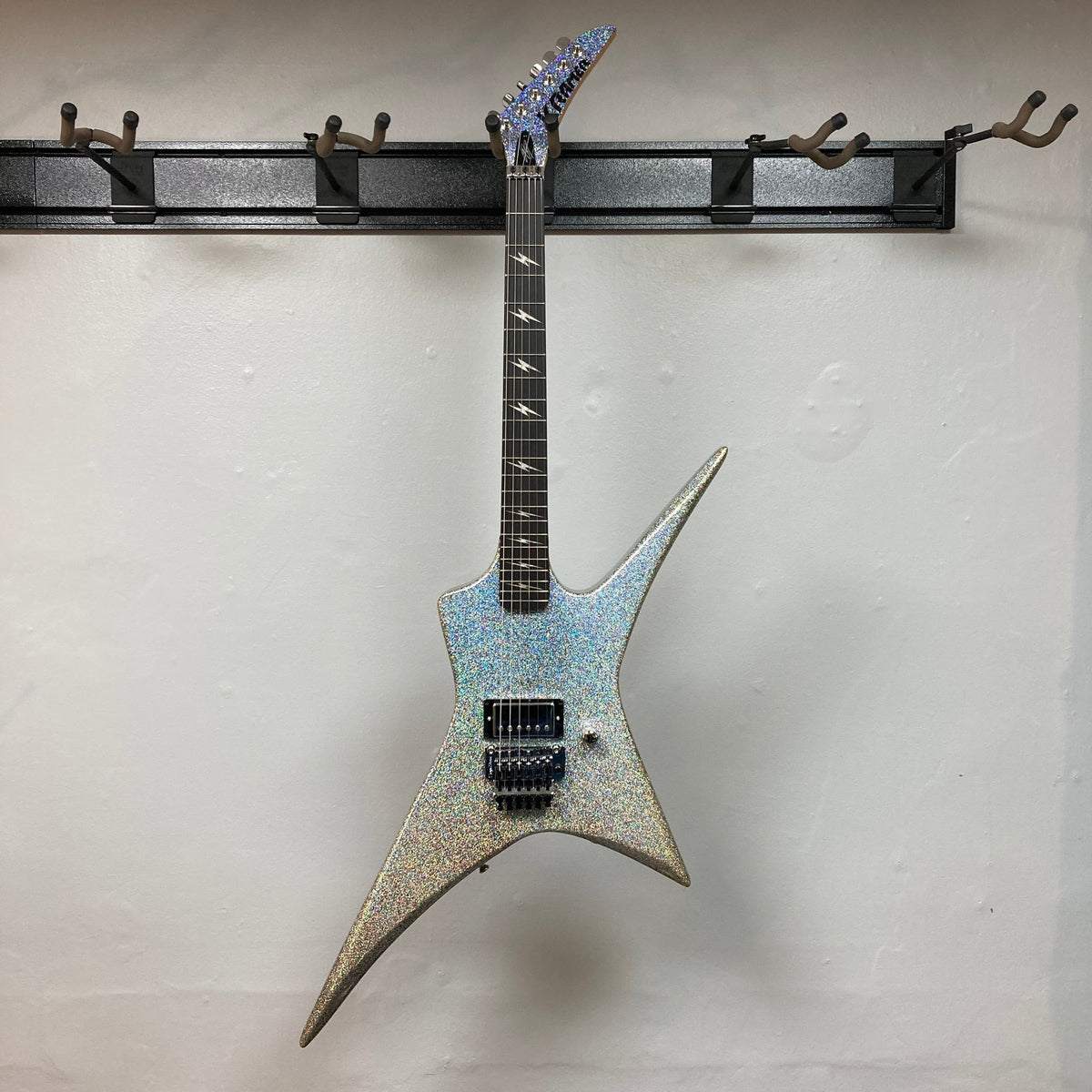 Kramer Lzzy Hale Voyager guitar on a wall hook, showcasing its bold design and high-performance features.