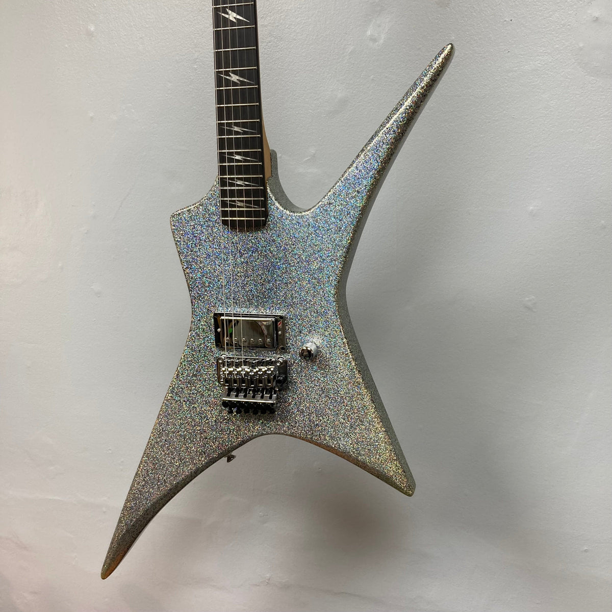 Kramer Lzzy Hale Voyager: sleek, silver guitar with black neck, close-up of strings and neck, ideal for rock enthusiasts.