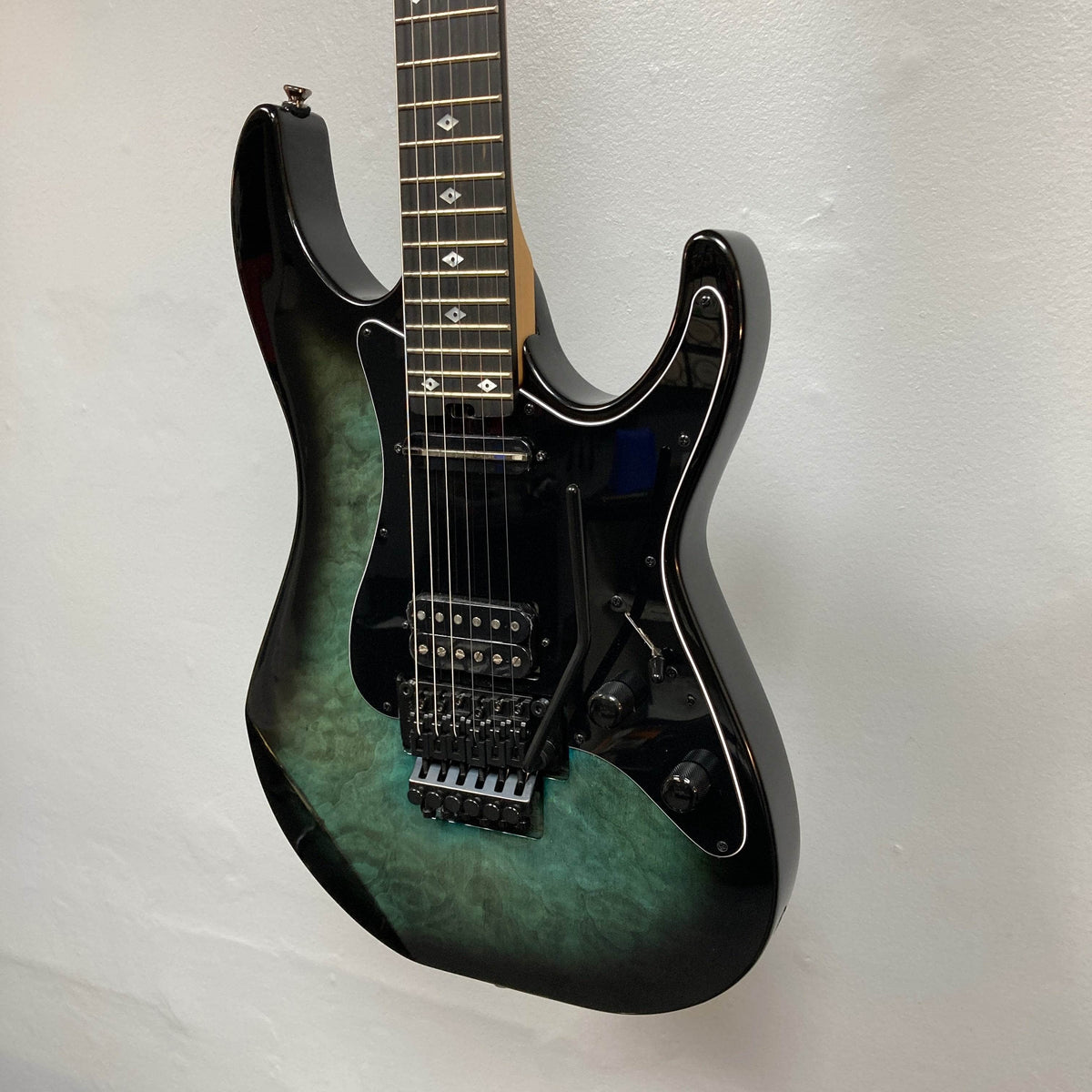Black burst electric guitar with a gradient finish on a light gray background