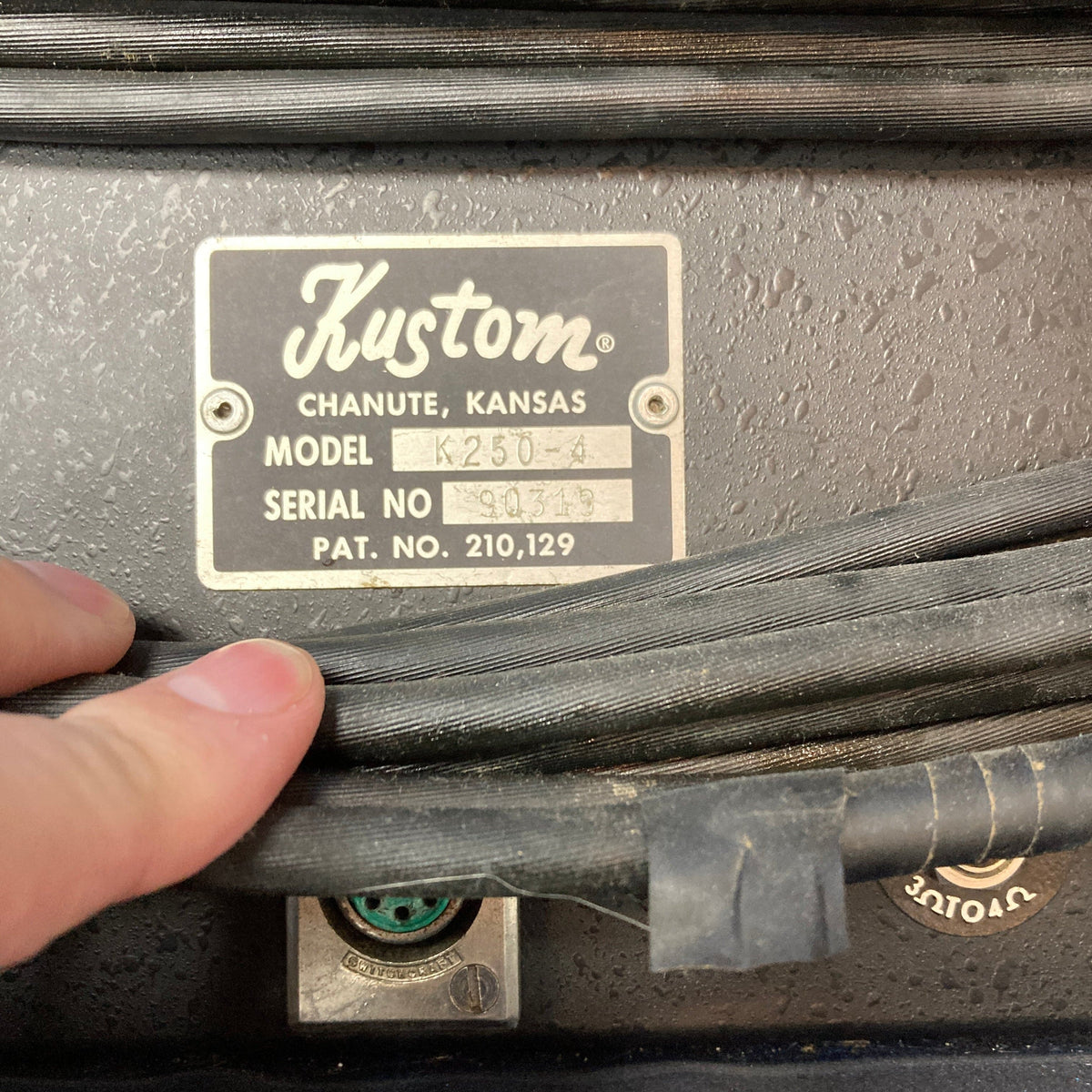 Kustom K250 Amp Head Blue Sparkle Tuck and Roll, held to showcase its retro design and solid-state power, perfect for vintage sound enthusiasts.