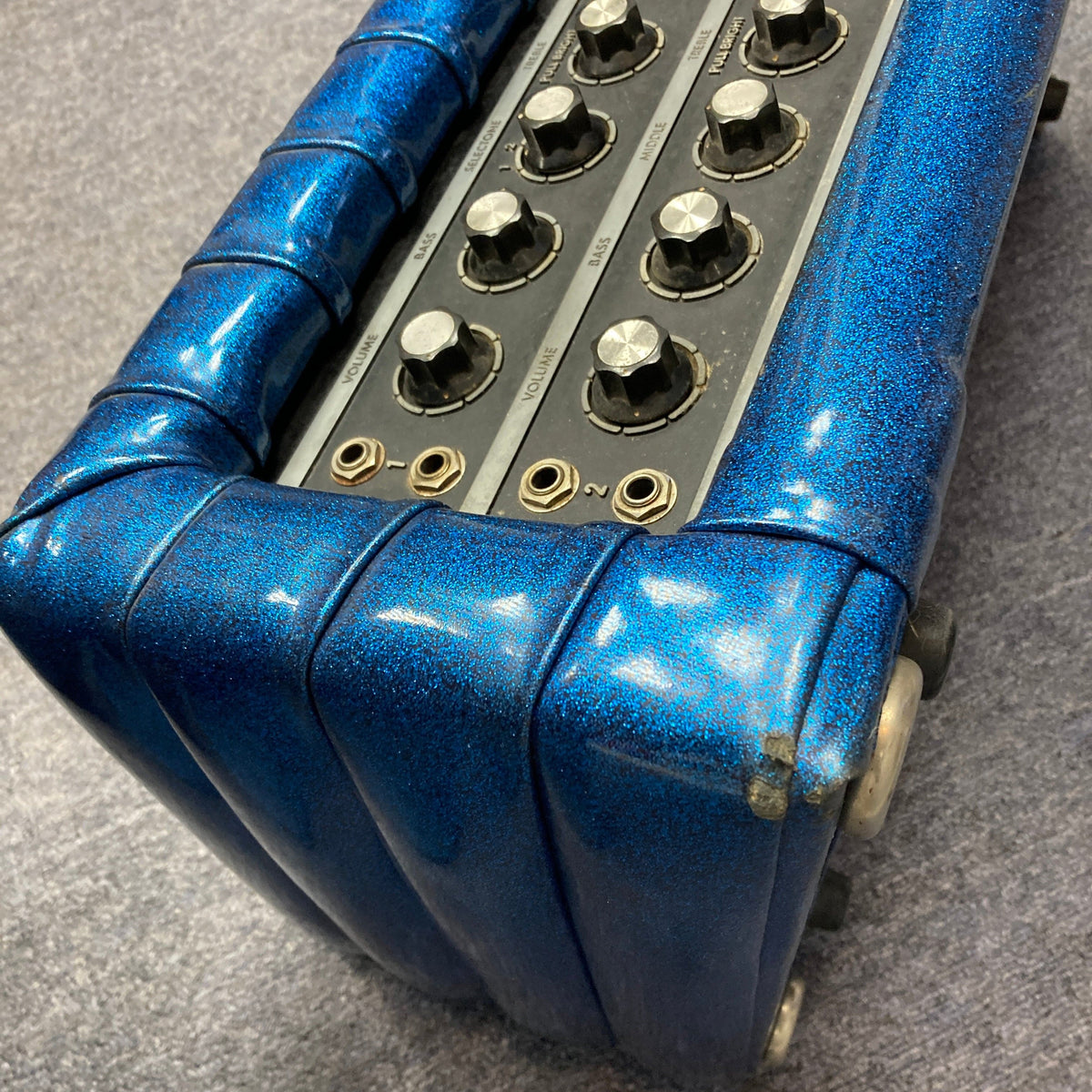 Kustom K250 Amp Head with blue sparkle design, featuring multiple knobs and a vintage style, known for its solid-state power and retro appeal.