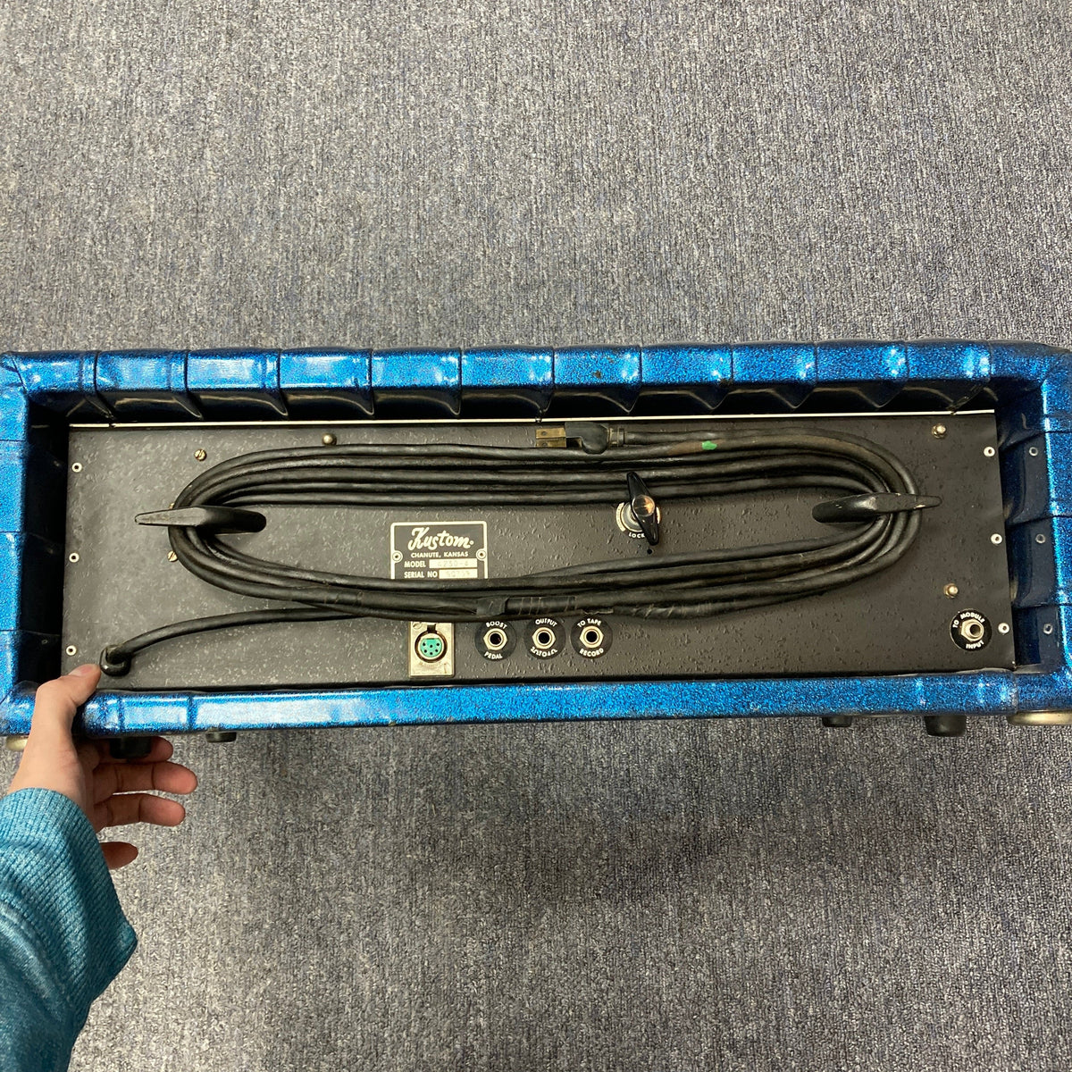 Kustom K250 Amp Head in blue sparkle, held in hand, showcasing retro design with wires visible, ideal for vintage sound enthusiasts.