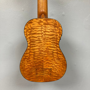 Close-up of Luna Bari-Bass Quilt Ash Top Bass Ukulele with Preamp and bag, showcasing the quilt ash body and walnut fingerboard.