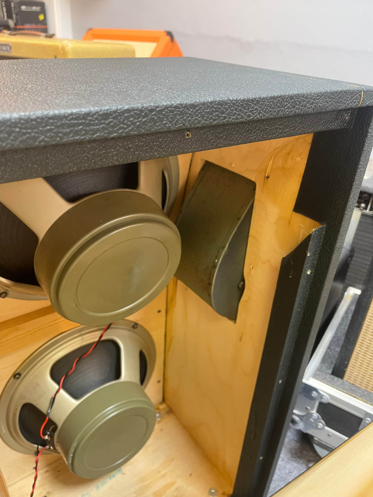 Inside view of a 1969 Marshall 4x12 Cabinet with Matching Celestion T1281 Greenbacks, featuring Pulsonic cones, wiring, and part of the internal wooden structure.