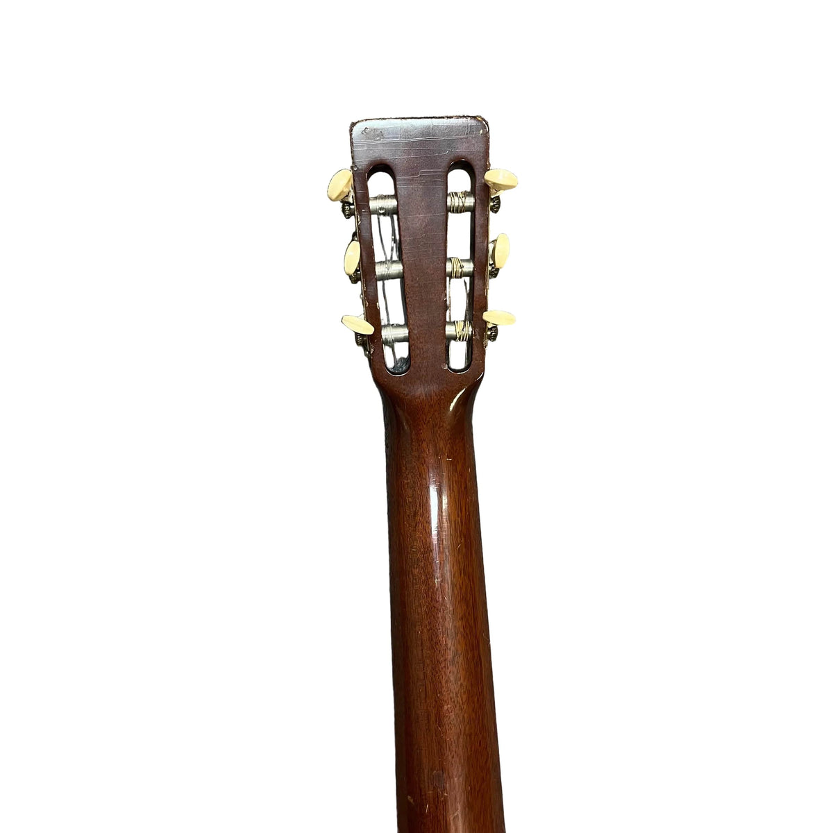 The back of a Martin 00-18G Classical Guitar (c. 1961–1962) by Martin, showing its headstock, neck, tuning pegs, and nylon strings against a white background.