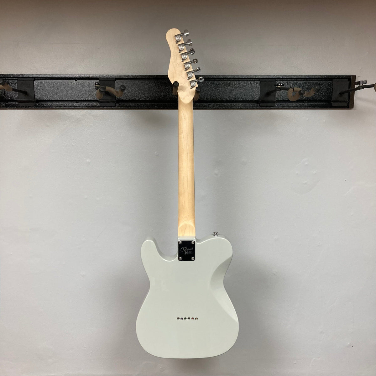 Michael Kelly 53 Tele Gloss Gray Prototype electric guitar with rainbow dots, displayed on a wall.