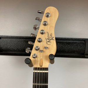 Michael Kelly Hybrid 55T Black Satin Blem guitar on stand, showcasing its dual pickups and sleek body design, ideal for versatile sound performance.
