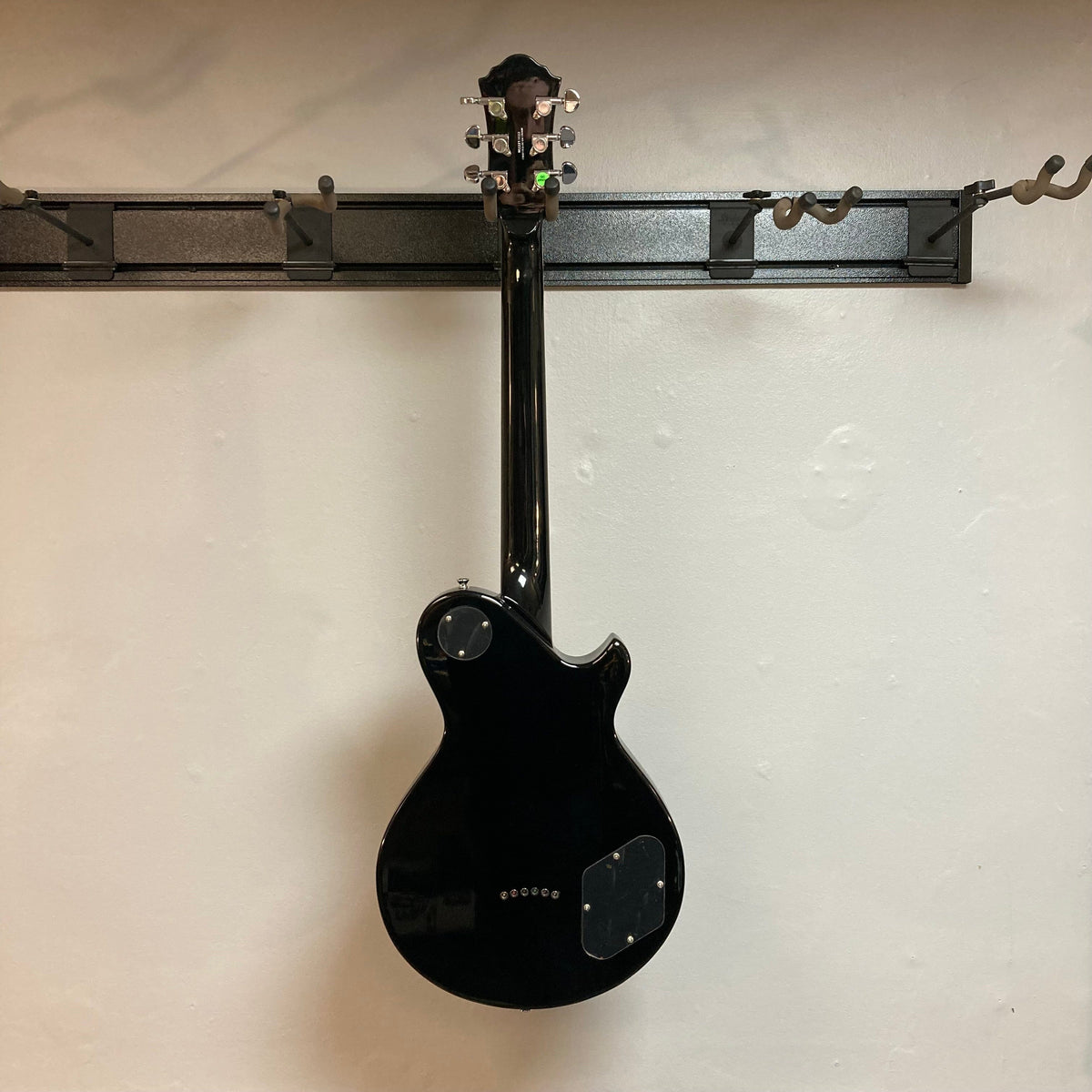 Michael Kelly Patriot Decree Lefty Black Blem, black electric guitar with PAF pickups, displayed on a wall.