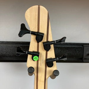 Close-up of the Michael Kelly Pinnacle 4 Bass guitar, highlighting its intricate burl poplar top and sleek ebony fretboard with diamond inlays.