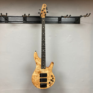 Michael Kelly Pinnacle 4 Bass guitar mounted on a wall, showcasing its detailed craftsmanship and design features.