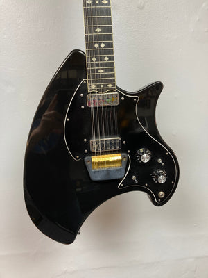 Ovation Deacon 12-String Electric Guitar in black, showcasing silver and gold strings and minor cosmetic imperfections on the headstock and pickguard.