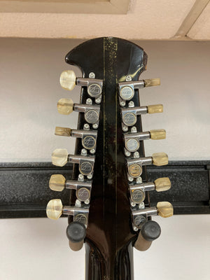 Close-up of an Ovation Deacon 12-String Electric Guitar, showcasing its solid body and 12-string configuration.