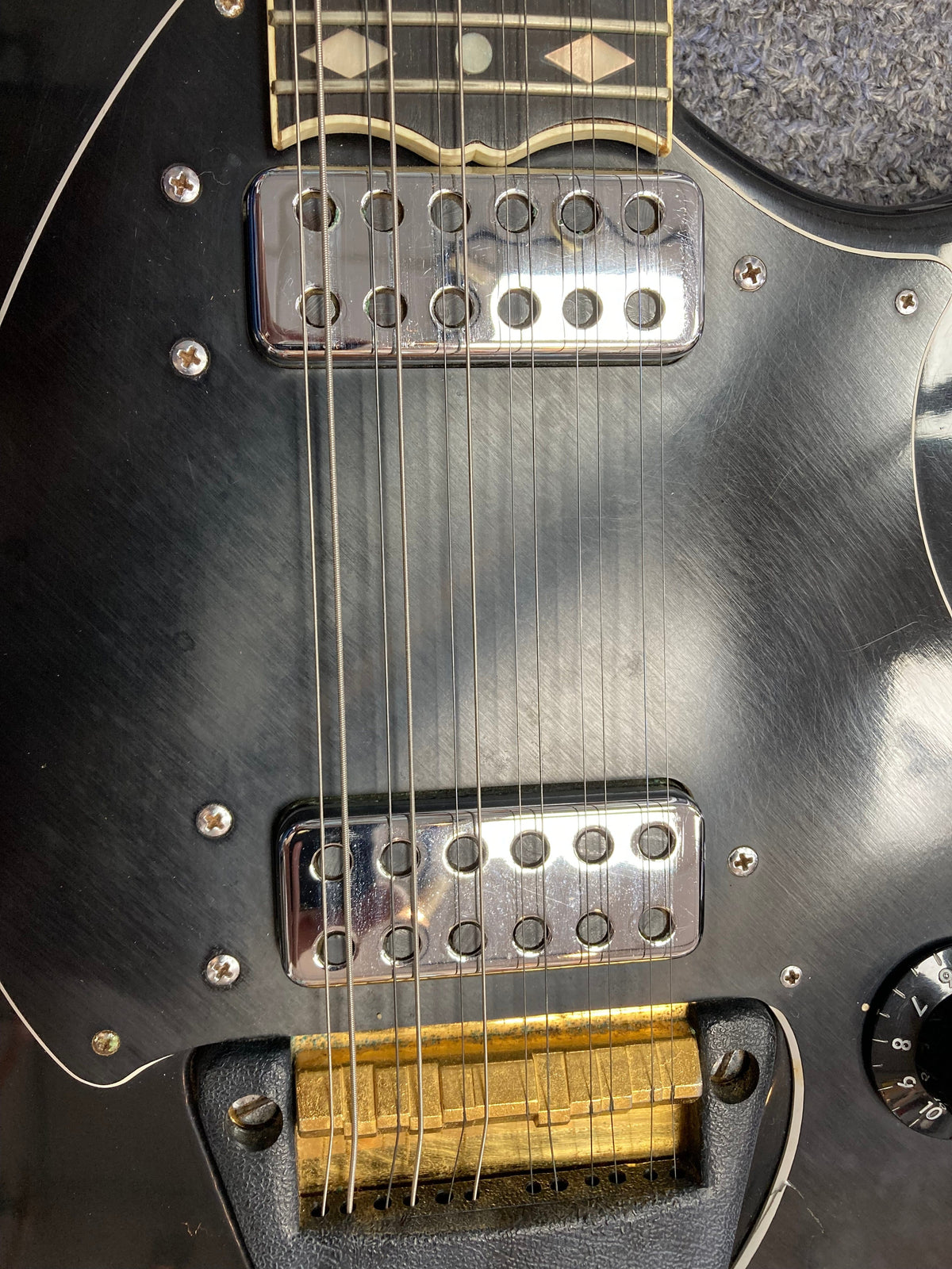 Ovation Deacon 12-String Electric Guitar in black, close-up showing strings and pickguard with minor cosmetic flaws.