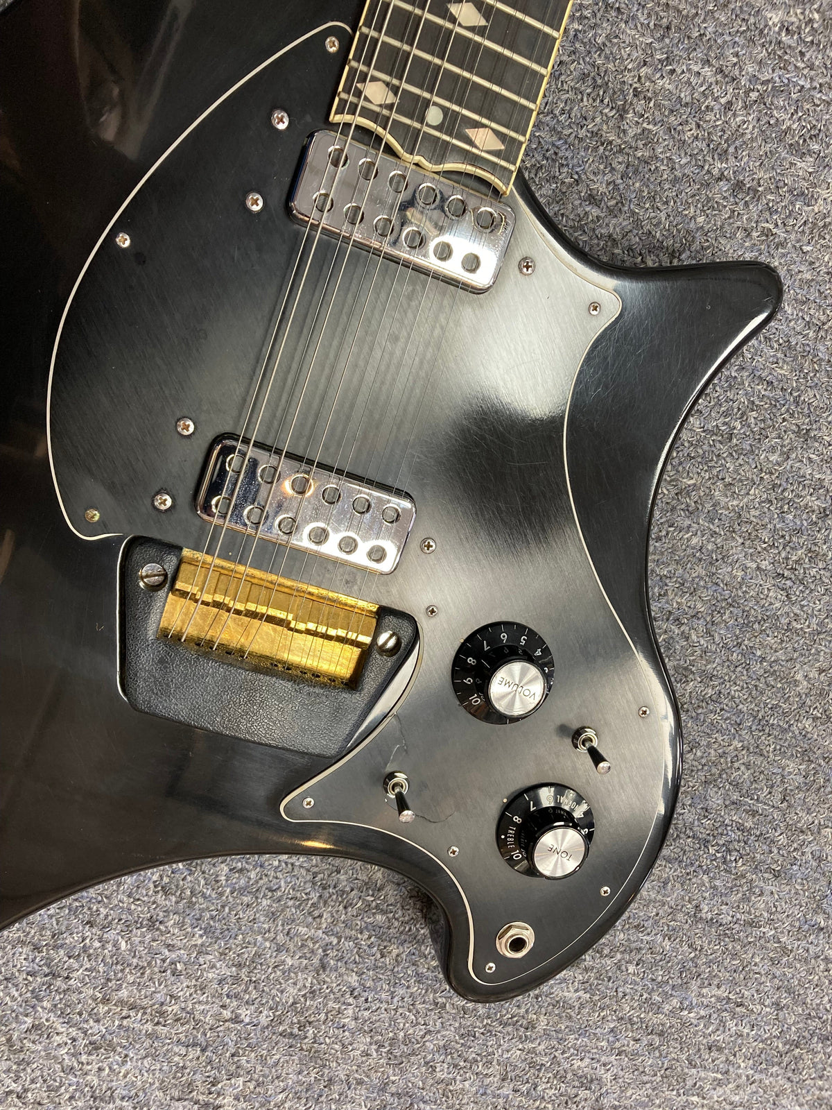 Black Ovation Deacon 12-String Electric Guitar, featuring knobs, switches, and minor cosmetic imperfections, highlighting its vintage charm and solid body design.
