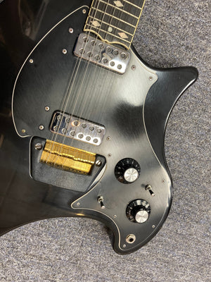 Black Ovation Deacon 12-String Electric Guitar, featuring knobs, switches, and minor cosmetic imperfections, highlighting its vintage charm and solid body design.