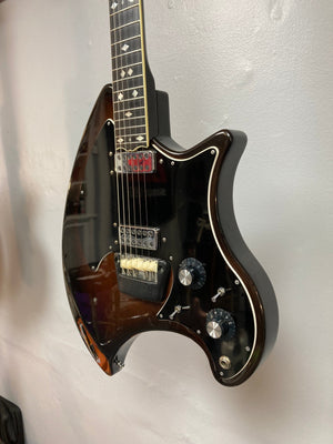 Ovation Deacon 1973-1975 sunburst electric guitar, well-preserved with minor wear, displayed on a wall, showcasing strings, dials, and neck details.