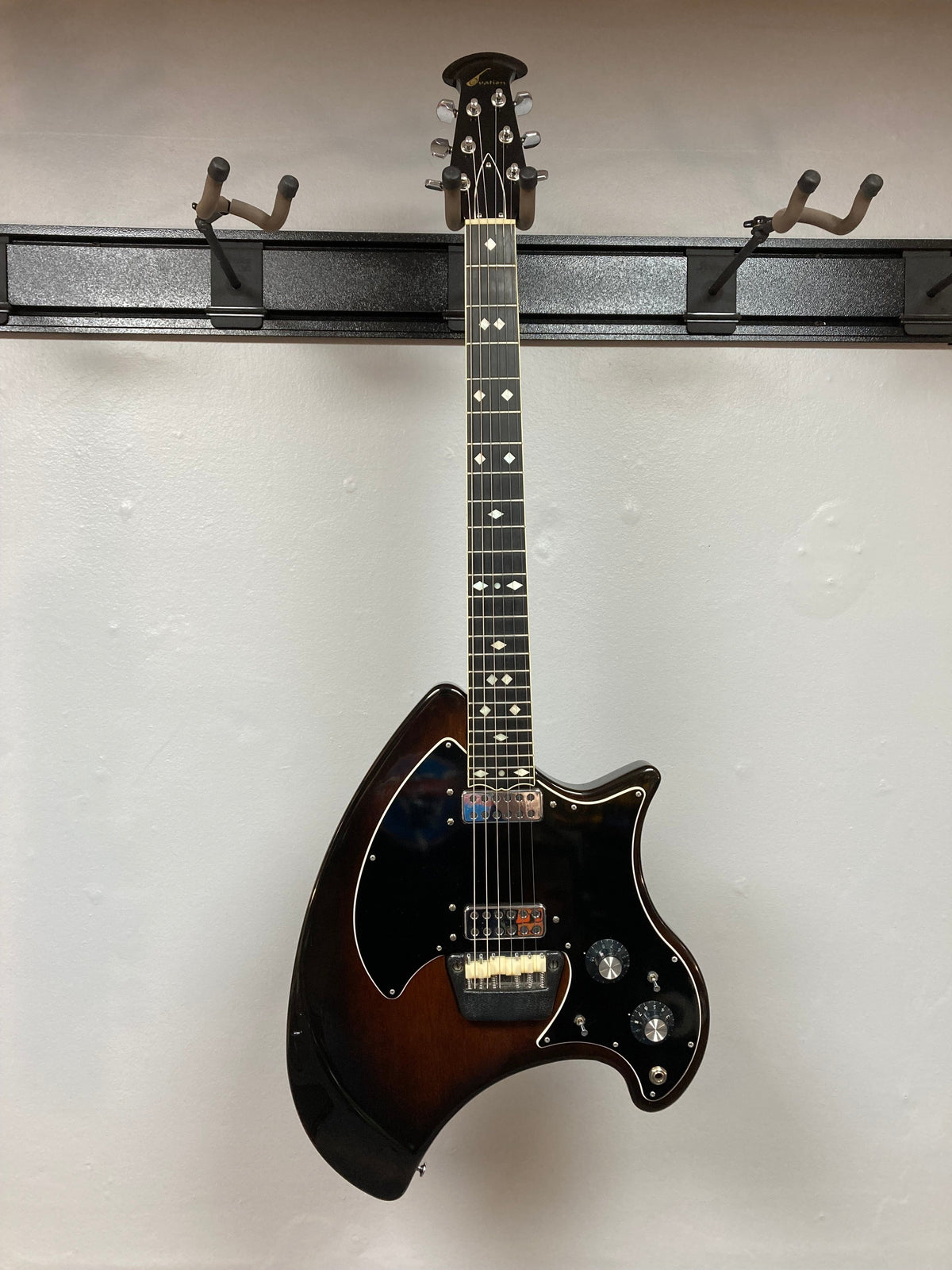 Ovation Deacon 1973-1975 Sunburst Electric Guitar displayed on a wall, showcasing its vintage appeal and well-preserved condition.