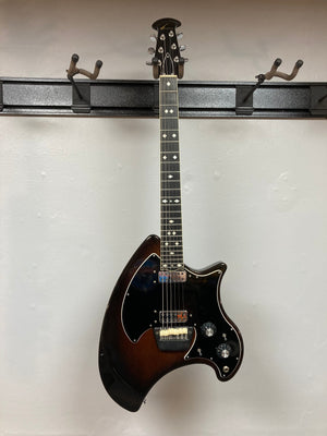Ovation Deacon 1973-1975 Sunburst Electric Guitar displayed on a wall, showcasing its vintage appeal and well-preserved condition.