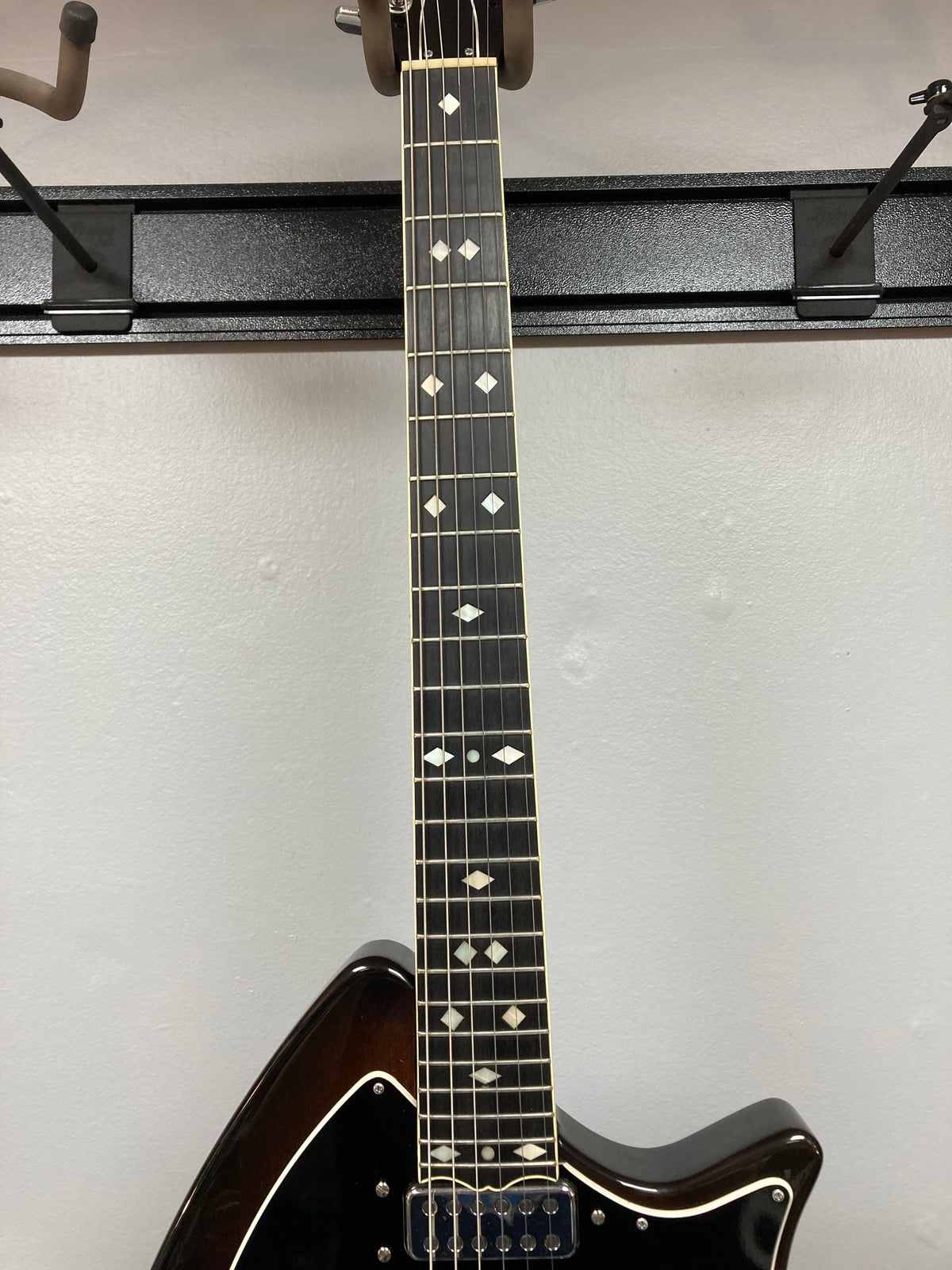 Ovation Deacon 1973-1975 - Sunburst Electric Guitar on a rack, showcasing its vintage sunburst finish and well-preserved condition.