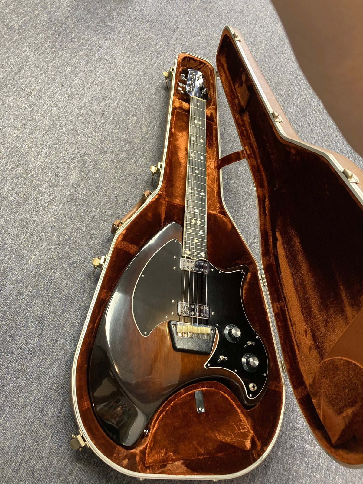 Ovation Deacon 1973-1975 Sunburst Electric Guitar in original case, showcasing a vintage vibe and well-preserved condition.
