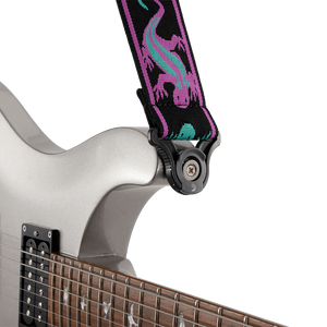 Close-up of a silver electric guitar fitted with a Planet Waves Auto Lock Guitar Strap in Green / Purple Lizards, securely attached to the instrument.