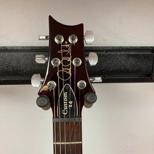 Headstock of a PRS Custom 24 Angry Larry 2011 electric guitar by PRS, featuring six tuning pegs, a gold signature, and a visible dark wood fretboard.