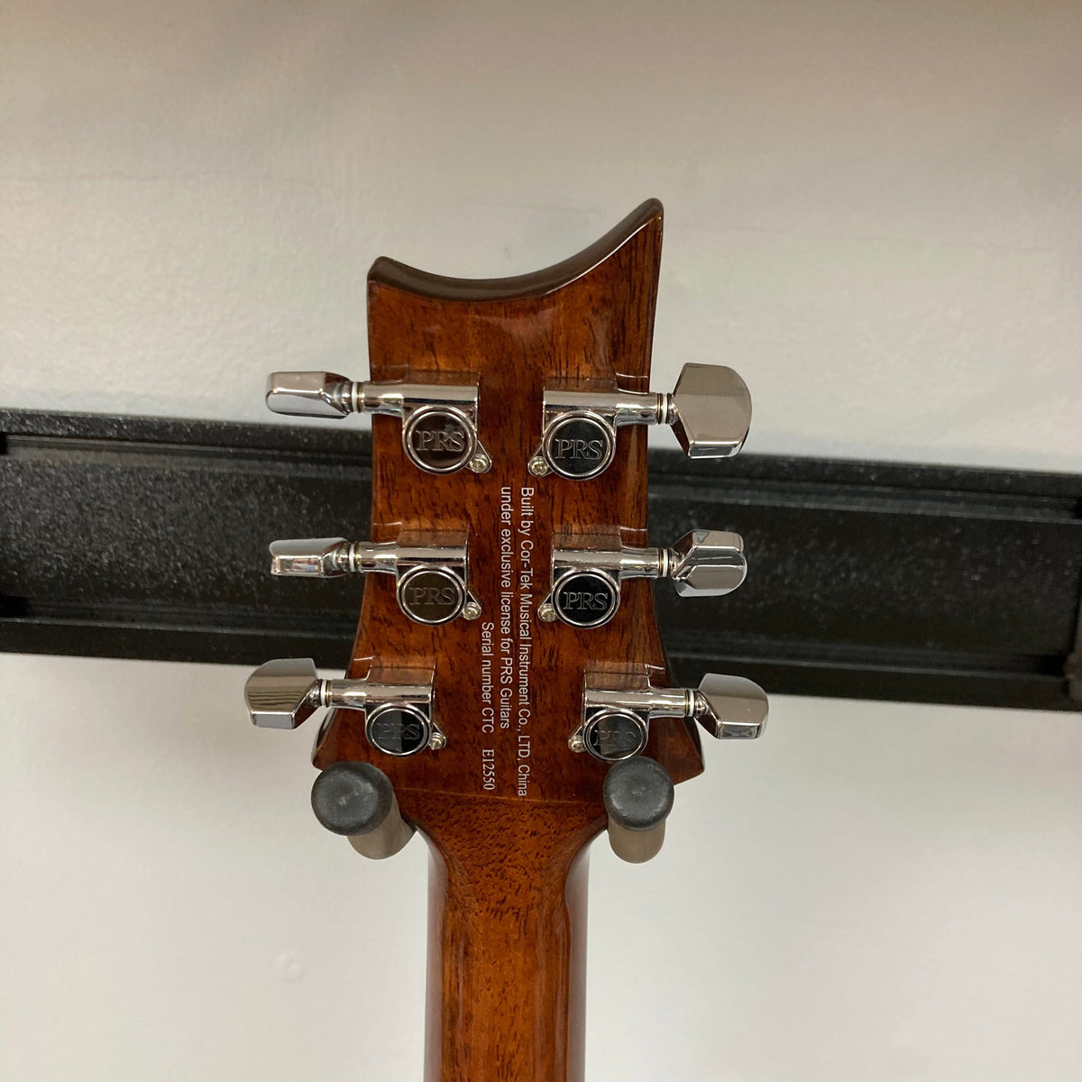 Close-up of PRS SE A50E guitar's body and logo, showcasing spruce top, maple back, and Fishman GT1 pickup system.