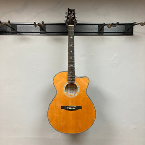 PRS SE A50E Charcoal Burst acoustic guitar with bird inlays, displayed on a wall.