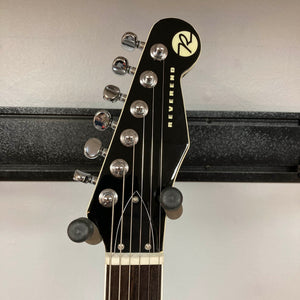 Close-up of the Reverend Greg Koch Signature Gristle 90 3-Tone Burst headstock with six tuning pegs, strings, and Reverend logo on black background; includes gigbag.