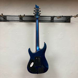 Schecter Hellraiser Hybrid C-1 FR S Sustainiac Ultra Violet Used, displayed on a wall, showcasing its electric guitar design with black knobs and a sleek finish.