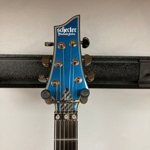 Schecter Hellraiser Hybrid C-1 FR S Sustainiac guitar on a stand, showcasing its Ultra Violet finish and black chrome hardware.