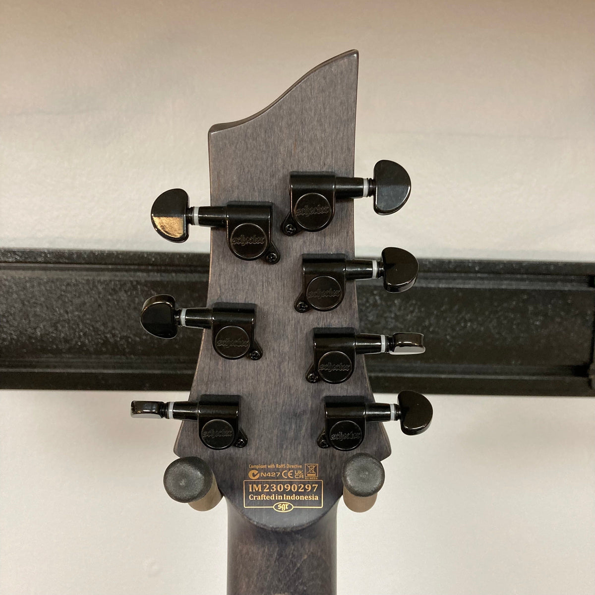 Schecter Omen Elite-7 Left-handed guitar with multiple control knobs, Heretic pickups, and a burl top.