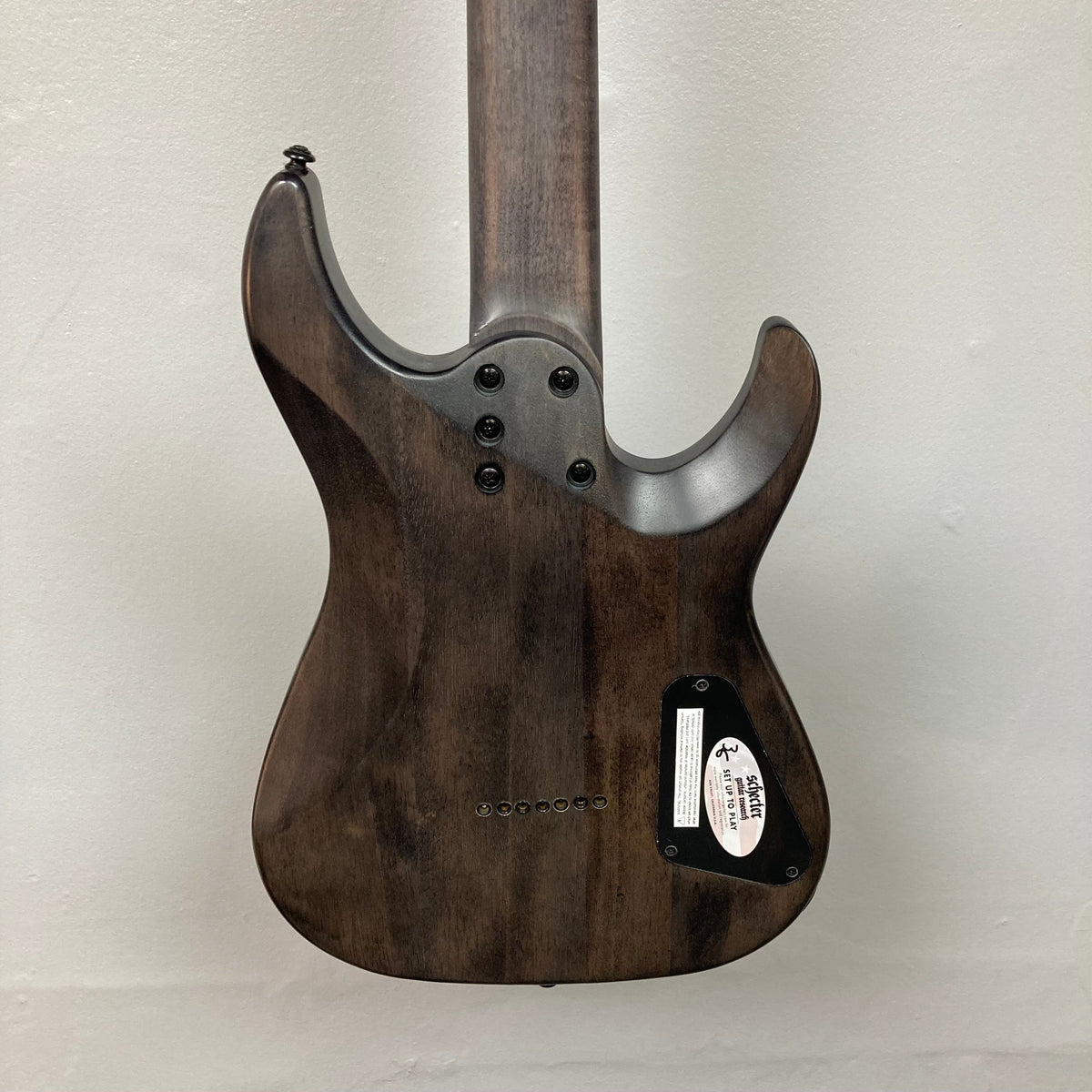 Schecter Omen Elite-7 Left-handed Black Cherry Burst Blemish, featuring a close-up of its guitar body and Heretic pickups.