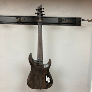 Schecter Omen Elite-7 Left-handed Black Cherry Burst Blemish, featuring burl top, Heretic pickups, and 7-string mahogany-maple construction, displayed on a wall.