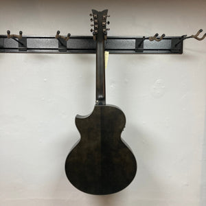 A Schecter Orleans Stage 7-String Acoustic Guitar hangs by its neck on a wall-mounted rack with empty hooks. Shown from the back, it displays its dark finish, body shape, and the Schecter brand’s tuning pegs on the headstock.