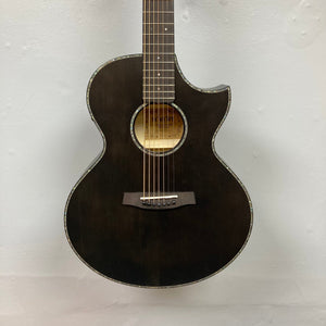 The Schecter Orleans Stage 7-String Acoustic Guitar by Schecter features a dark finish, single cutaway, abalone-style body trim, and an Engelmann spruce top. It is pictured against a plain light-colored wall.